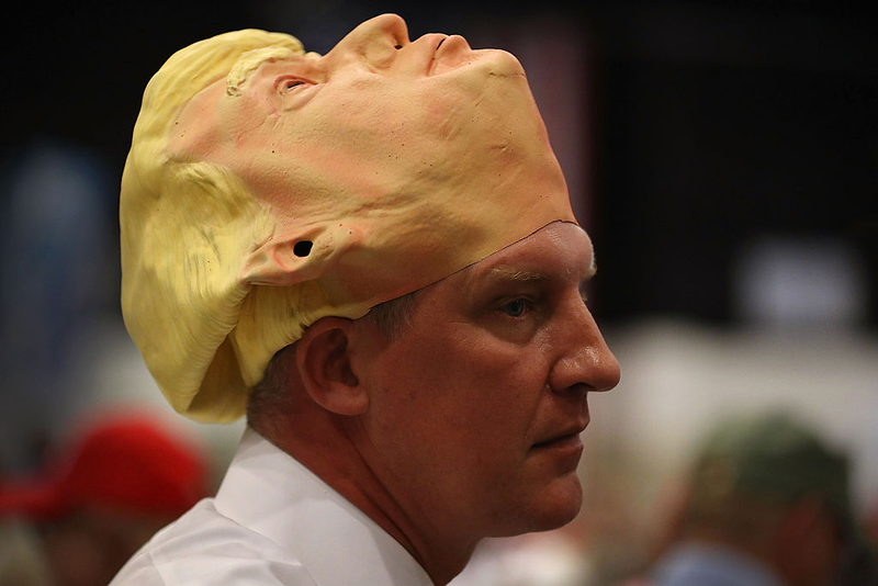Derek Olsen wears a Trump mask at a rally in West Palm Beach, Florida. (Photo by Joe Raedle/Getty Images)